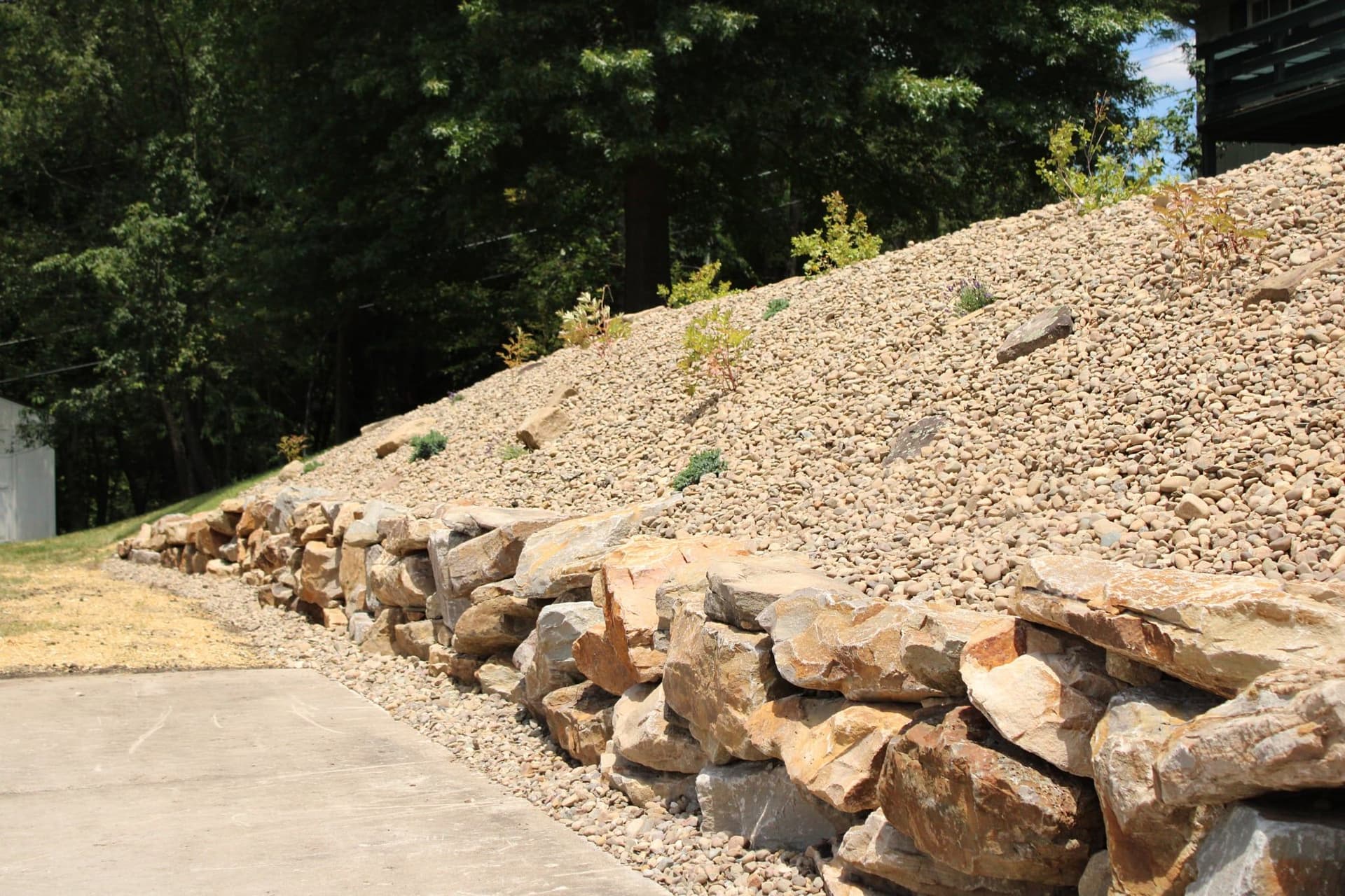 Steep Bank Turned Low-Maintenance With a Stone Retaining Wall image